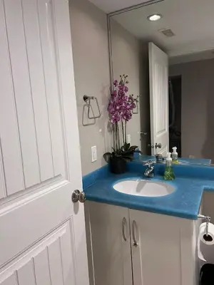 a bathroom with a sink with a blue counter top at Vancouver Comfort Home 10 min to YVR airport, Close to Downtown in Vancouver
