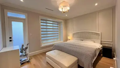 a bedroom with a bed and a window and a chair at Vancouver Richmond Villa 41 in Richmond