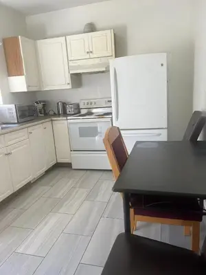 a kitchen with a table and a white refrigerator at one private room in Victoria