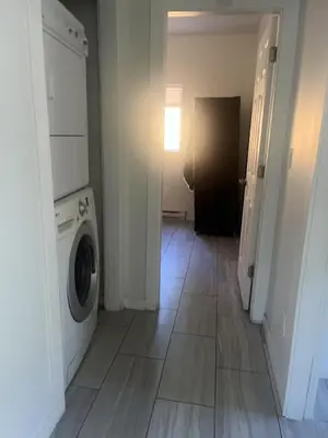 a laundry room with a washer and dryer on a tile floor at one private room in Victoria