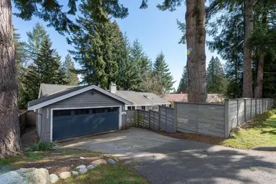 a house with a garage and a fence at Northern Stay in North Vancouver