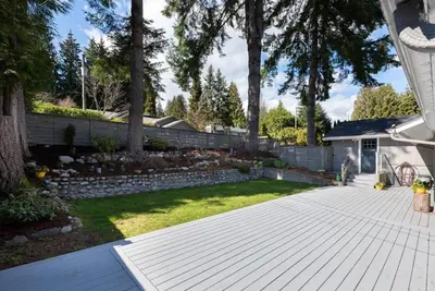 a backyard with a wooden deck and a yard at Northern Stay in North Vancouver