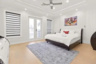a white bedroom with a bed and a ceiling fan at Spacious 6BR Entire Home Sleeps 14 Private Parking Pet-Friendly Near Vancouver in Surrey