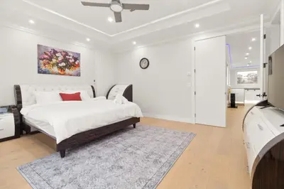 a white bedroom with a bed and a rug at Spacious 6BR Entire Home Sleeps 14 Private Parking Pet-Friendly Near Vancouver in Surrey