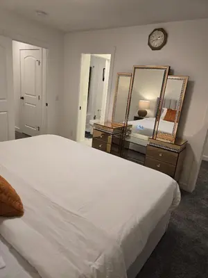 a bedroom with a large bed and two mirrors at Modern Comfort - With AC in Calgary