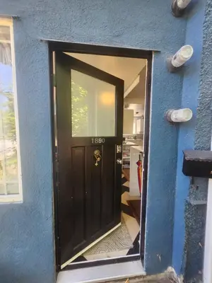 a black door in a blue house with a window at Lakeview Suite by Trout Lake in Vancouver