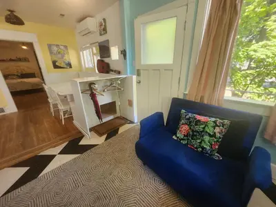a living room with a blue couch and a dining room at Lakeview Suite by Trout Lake in Vancouver