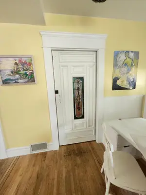 a room with a table and a door with a window at Lakeview Suite by Trout Lake in Vancouver