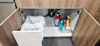 a cupboard with some cleaning items in it at 1 BR suite near WEM, with fast WiFi and Equipped kitchen in Edmonton