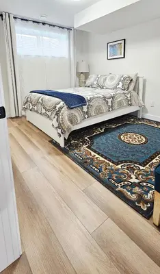 a bedroom with a bed and a rug on the floor at 1 BR suite near WEM, with fast WiFi and Equipped kitchen in Edmonton