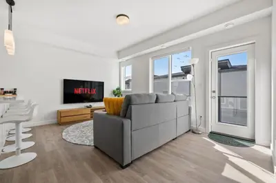 a living room with a couch and a tv at Two Bedroom Townhouse with AC Garage Parking and Wifi in Calgary