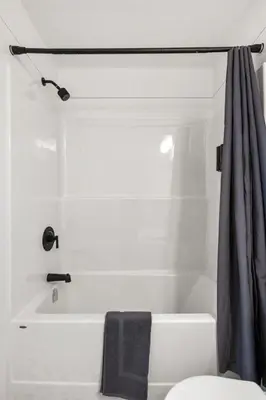 a bathroom with a white tub and a shower curtain at Two Bedroom Townhouse with AC Garage Parking and Wifi in Calgary