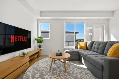 a living room with a couch and a tv at Two Bedroom Townhouse with AC Garage Parking and Wifi in Calgary