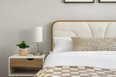 a bedroom with a bed and a night stand with a plant at Large House with Billiards, 5 Bedrooms, Garage Parking & Free Banff Access in Calgary