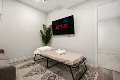 a living room with a tv on a wall at Large House with Billiards, 5 Bedrooms, Garage Parking & Free Banff Access in Calgary