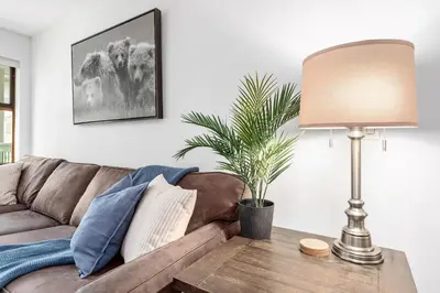 a living room with a brown couch and a lamp at 1BR in Northstar, Village Location, Hot Tub, Gas Fireplace, Secure Parking, Ski Storage in Whistler
