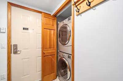 a laundry room with a washer and dryer next to a door at 1BR in Northstar, Village Location, Hot Tub, Gas Fireplace, Secure Parking, Ski Storage in Whistler