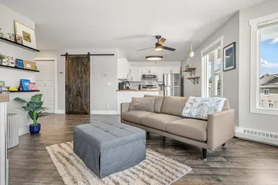 a living room with a couch and a table at Lakefront Lookout 1BR Condo on Lakeshore Drive in Sylvan Lake