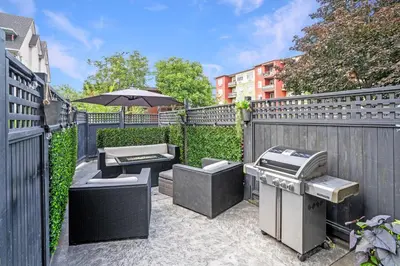 an outdoor patio with a grill and an umbrella at The Rosemead Suite in Kelowna