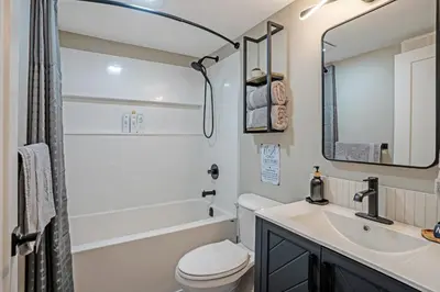 a bathroom with a sink and a toilet and a mirror at The Rosemead Suite in Kelowna