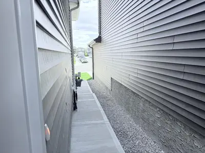 a side walk next to a building at Cozy 2BR Basement Rosenthal Stay by WEM with private entrance in Edmonton