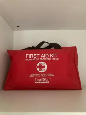 a red first aid bag sitting on a wall at Cozy 2BR Basement Rosenthal Stay by WEM with private entrance in Edmonton