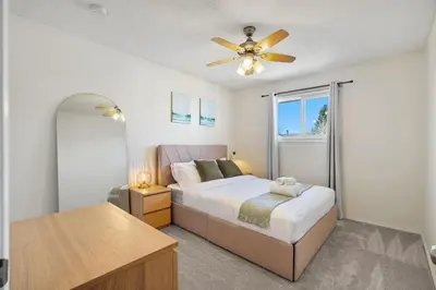 a bedroom with a bed and a ceiling fan at Cozy Modern Pet Friendly Homes in Calgary