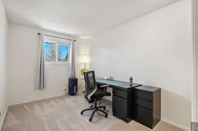 an office with a desk and a chair in a room at Cozy Modern Pet Friendly Homes in Calgary