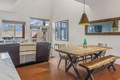 a dining room and living room with a table and chairs at Amazing mountain Views 3BR Penthouse with private Balconies in Canmore