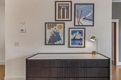 a room with a table with pictures on the wall at Amazing mountain Views 3BR Penthouse with private Balconies in Canmore