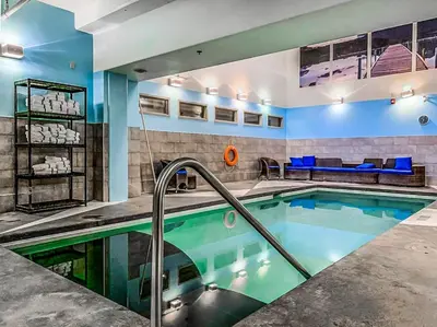 a swimming pool in a room with a couch and a couch at Amazing mountain Views 3BR Penthouse with private Balconies in Canmore