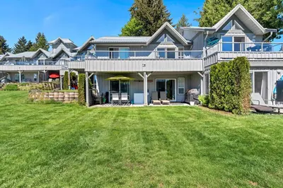 a large house with a lawn in front of it at Lakefront Suite on Shawnigan Lake in Shawnigan Lake