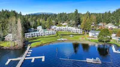 an aerial view of a large house on a lake at Lakefront Suite on Shawnigan Lake in Shawnigan Lake