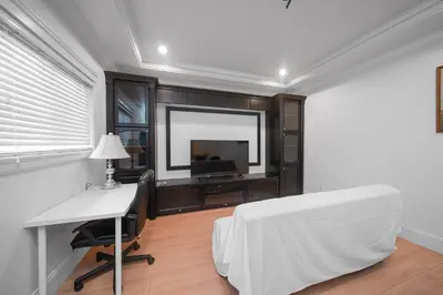 a bedroom with a bed and a desk and a television at Guest suite in Richmond in Richmond