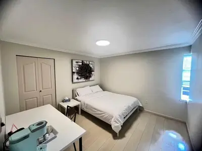 a small bedroom with a bed and a table at Luxurious and quiet room in Vancouver's West End in Vancouver