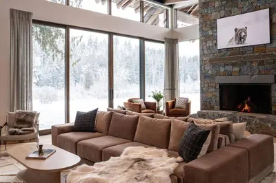 a living room with a couch and a fireplace at Mountain Lake Luxury Ski Chalet in Revelstoke