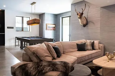 a living room with a couch and a pool table at Mountain Lake Luxury Ski Chalet in Revelstoke