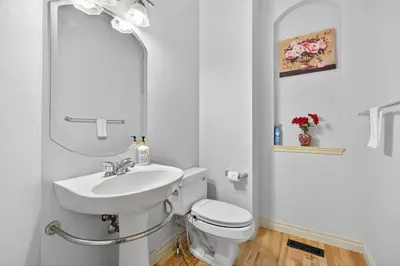 a white bathroom with a sink and a toilet at Luxury Home with 5 BR, 9 Beds, 4BA, sleep 12, AC, Crib in Calgary