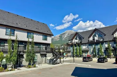 a group of buildings with a mountain in the background at Cloudline Vista 3 BdrmTownhouse with Garage managed by Little Sister Getaways in Canmore