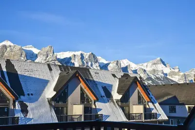 a row of houses with mountains in the background at Cloudline Vista 3 BdrmTownhouse with Garage managed by Little Sister Getaways in Canmore