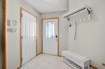 a room with a white door and a air conditioner at Peacock Suites in Airdrie