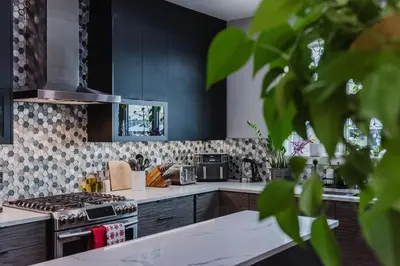 a kitchen with black cabinets and a stove at NordicSauna 3 Ensuite baths TheYellowDoorRetreat in Edmonton