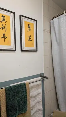 a bathroom with two framed pictures on the wall at YEGFamilyHome in Edmonton