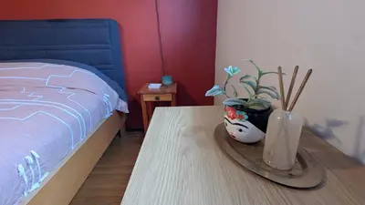 a bedroom with a bed and a table with a vase with a plant at YEGFamilyHome in Edmonton