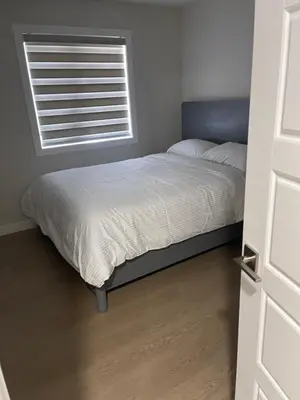 a bed in a bedroom with a window at A3 Home in Secord in Edmonton