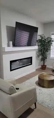 a living room with a fireplace with a tv above it at A3 Home in Secord in Edmonton