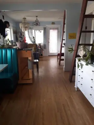 a living room with a wooden floor and a ladder at Trout House by Trout Lake in Vancouver