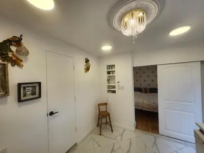 a hallway with a room with a bed and a chandelier at Garden View double room suite at Trout Lake in Vancouver