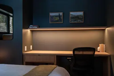 a bedroom with a desk and a chair next to a bed at Ghost Peak Chalet - Ski-In Access in Port Mann
