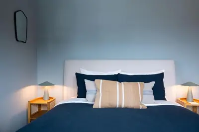 a blue bedroom with a large bed with pillows at Ghost Peak Chalet - Ski-In Access in Port Mann